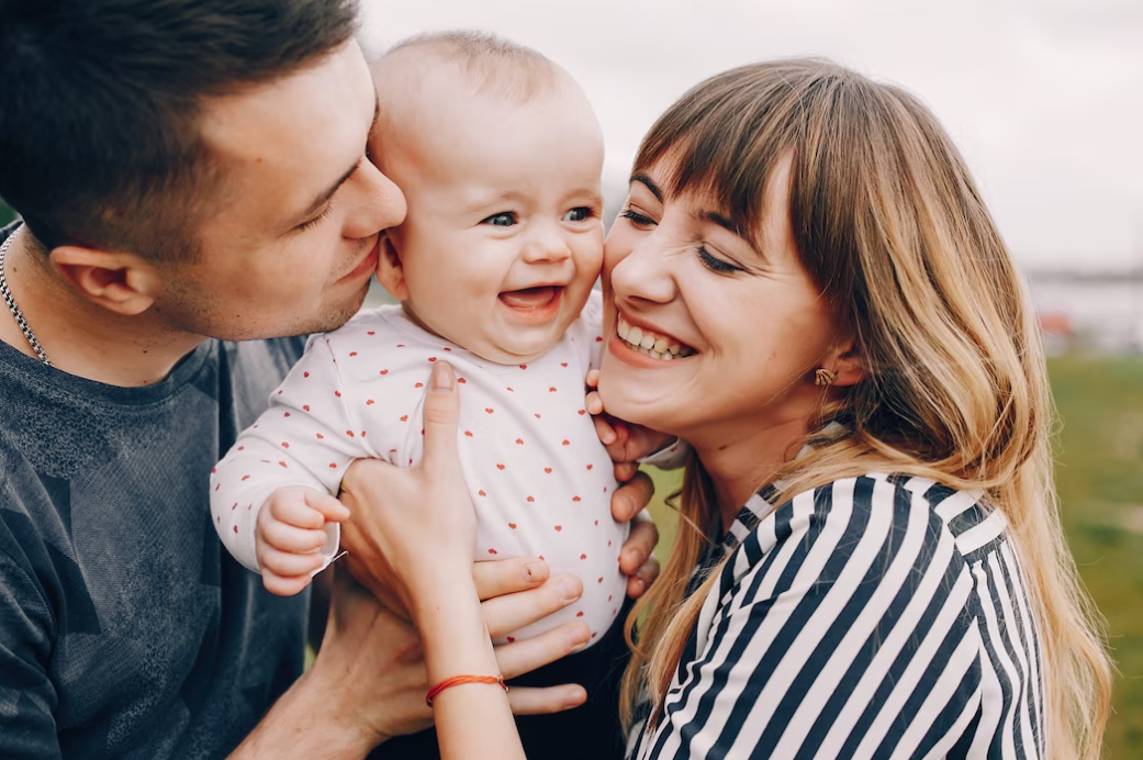 Mother and father playing and smiling in a summer park