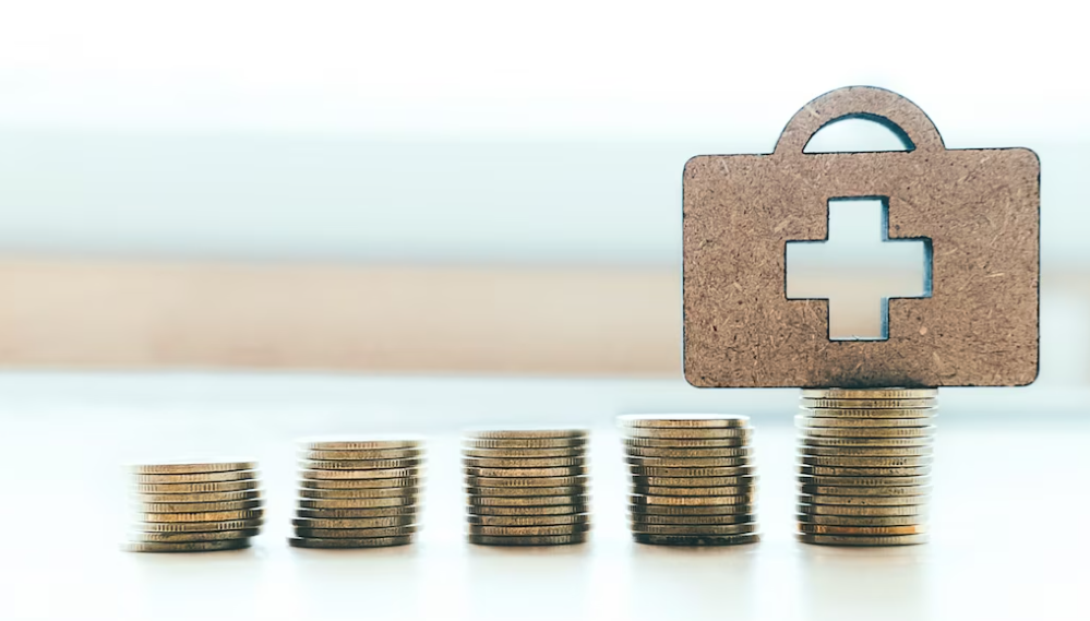 a stock of coins, and a wooden figure of a suitcase with a cross on it