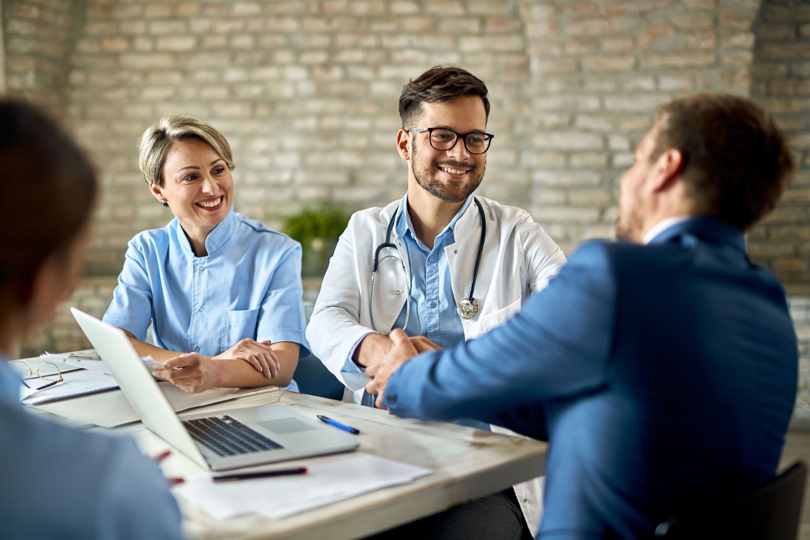 Group of healthcare workers greeting man in the office