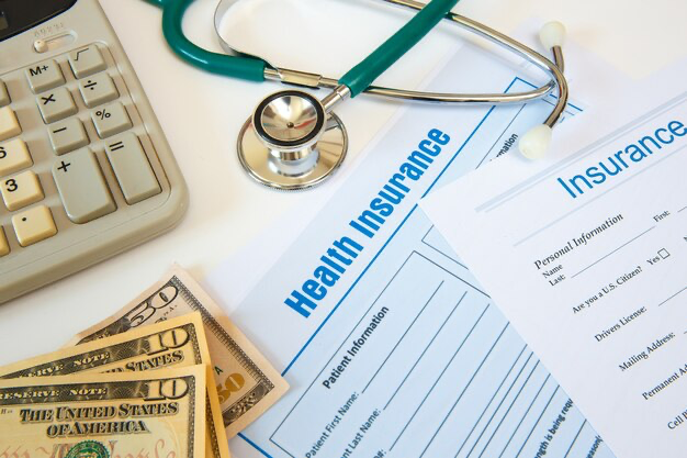 Medical insurance next to money, calculator and stethoscope